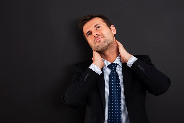 Businessman having pain in the neck
