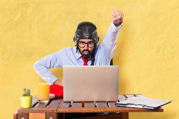 Free photo businessman in his office with pilot hat