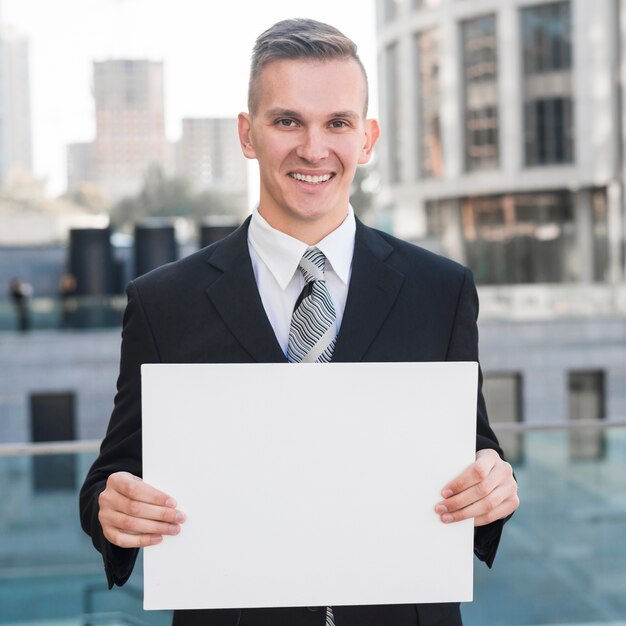 Businessman holding blank paper template