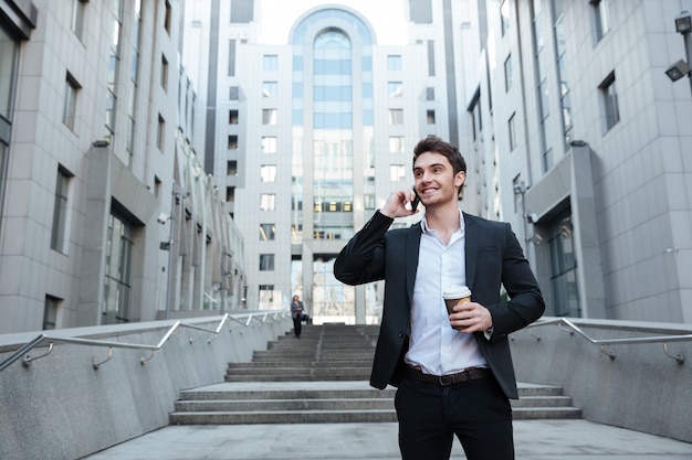 Free photo businessman holding coffee and phone