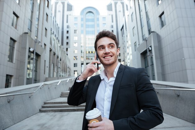 Businessman holding coffee and phone