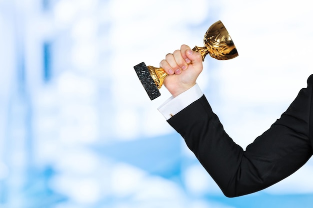 Businessman holding golden cup trophy