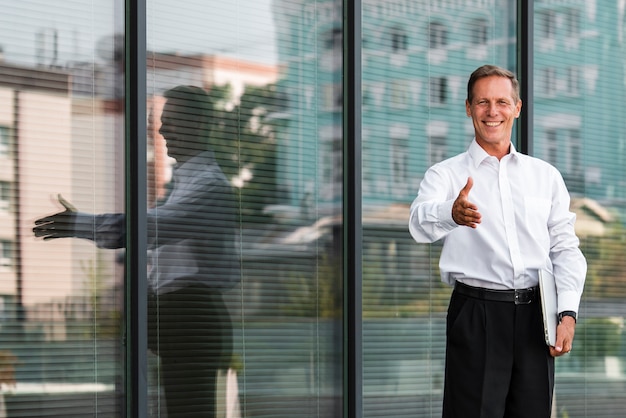 Businessman holding hand out near building