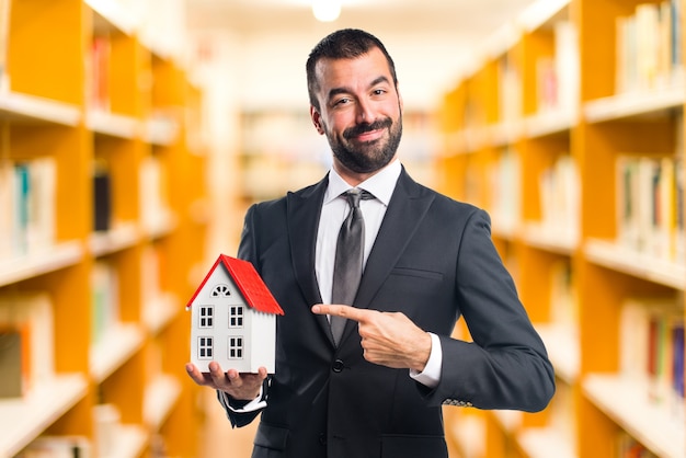 Businessman holding a little house