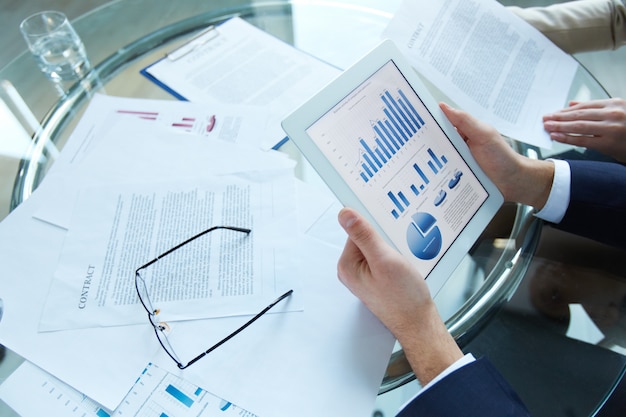 Free photo businessman holding a tablet with statistical data