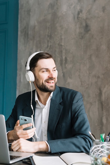 Businessman listening to music and looking away