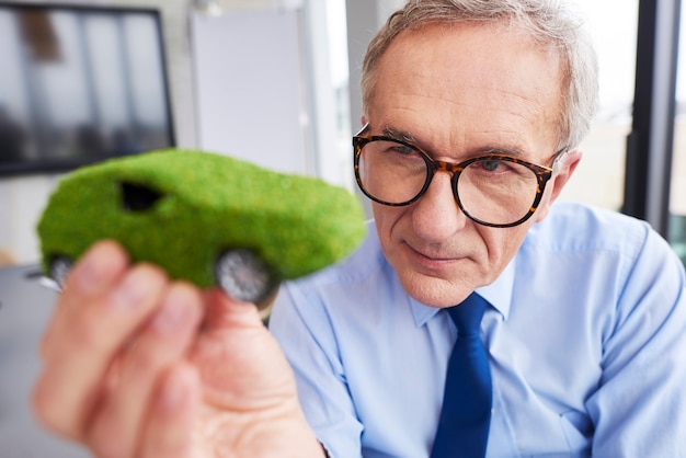 Free Photo businessman looking at eco friendly car