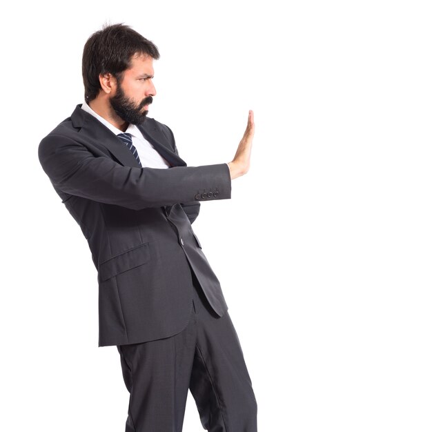 Businessman making stop sign over white background