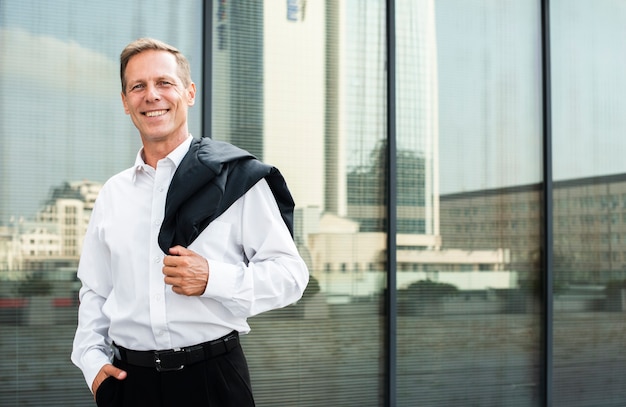 Free Photo businessman near glass building looking at camera