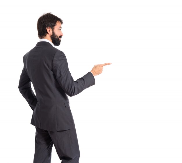 Businessman pointing to the lateral over white background