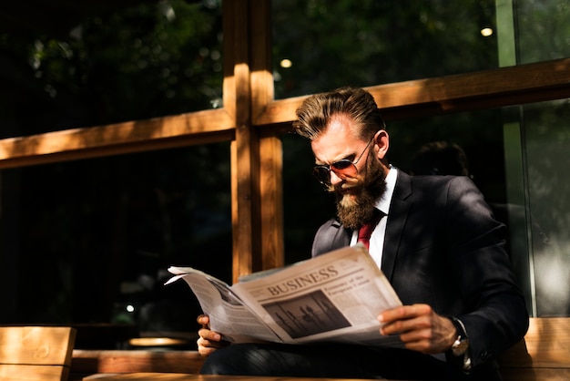 Businessman reading newspaper at coffee shop