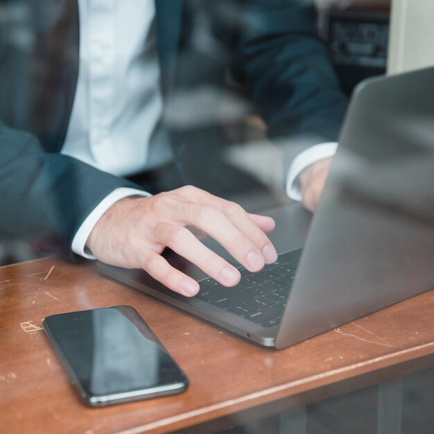 Businessman's hand typing on laptop over the desk