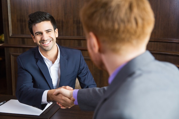 Free Photo businessman shaking hands with another businessman