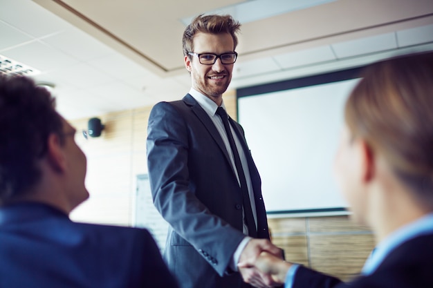 Free photo businessman shaking hands with his workmate