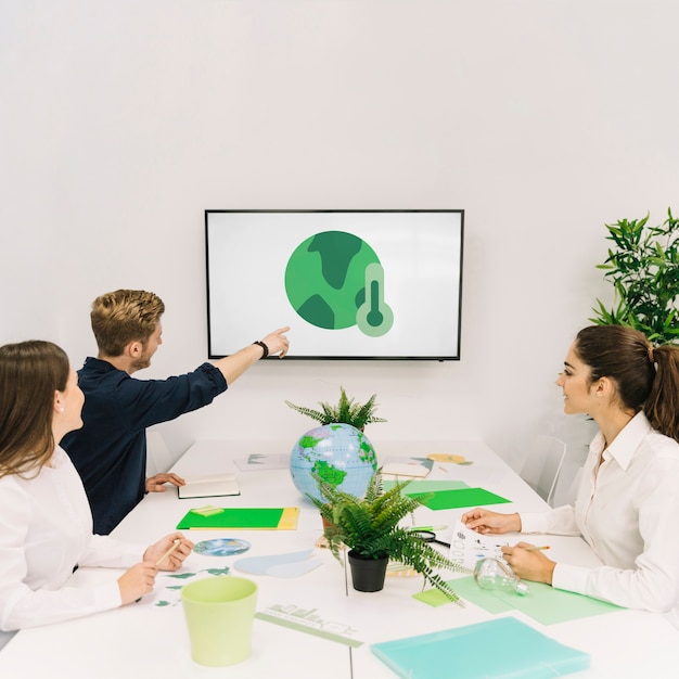 Businessman showing global warming icon to his colleagues on screen