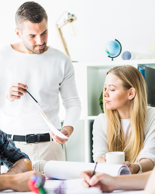 Free photo businessman showing graph to his female colleague