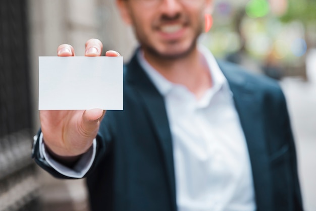 Free photo businessman showing white visiting card toward camera