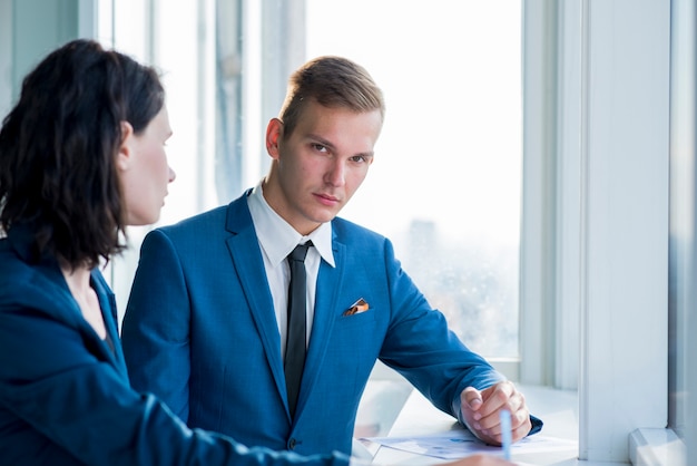 Businessman sitting with his female colleague in office