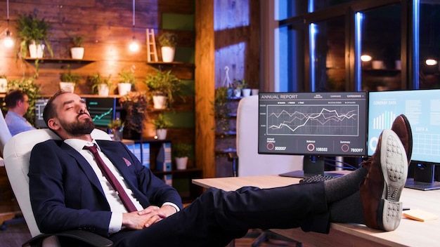 Free Photo businessman sleeping with his feet on the table. modern office and moon light