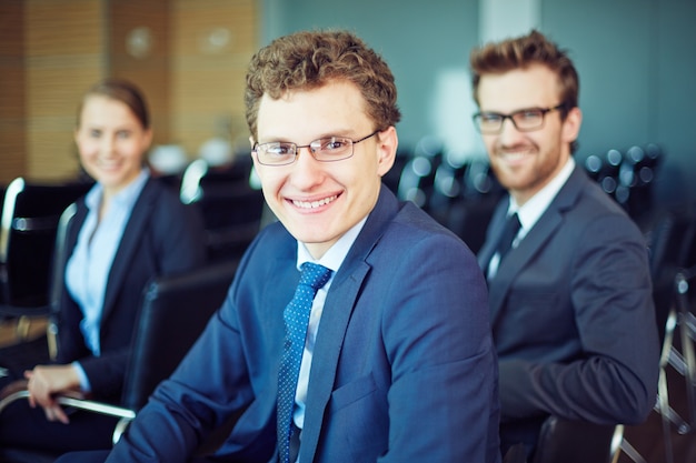 Businessman smiling with workers background