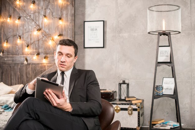 Businessman in suit browsing tablet 