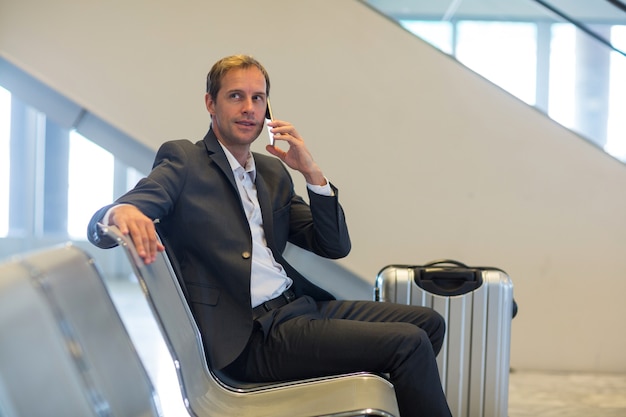 Free photo businessman talking on mobile phone in waiting area