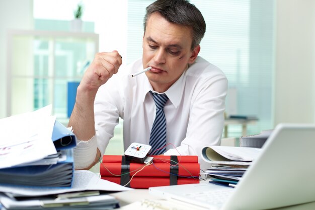 Businessman thinking while smoking a cigarette