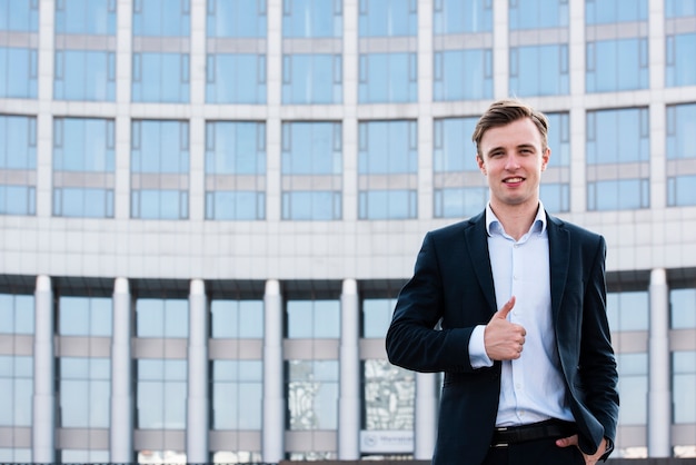 Businessman thumbs up looking at camera