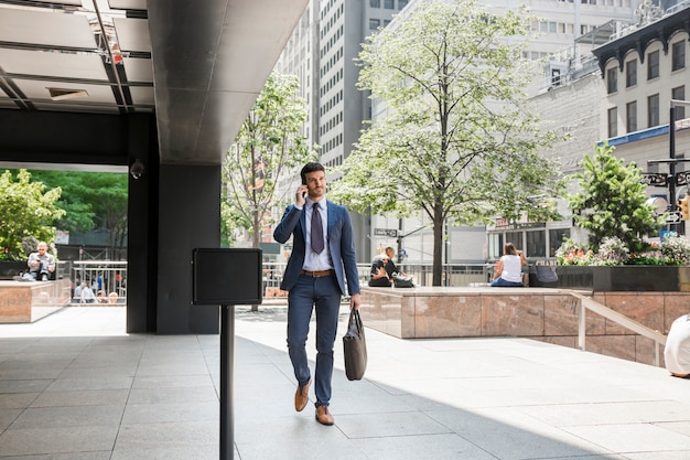 Businessman walking to work and speaking on phone