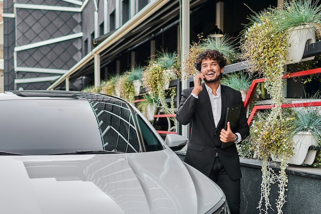 A businessman walks past his car