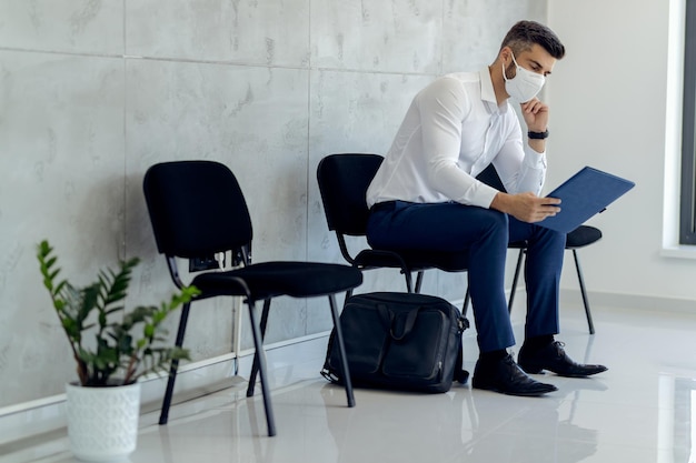 Businessman wearing protective face mask while waiting or job interview