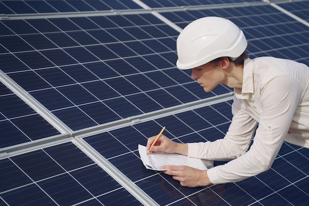 Free Photo businessman in a white helmet near solar battery