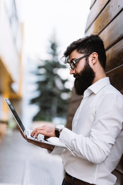 Businessman in white shirt typing on laptop