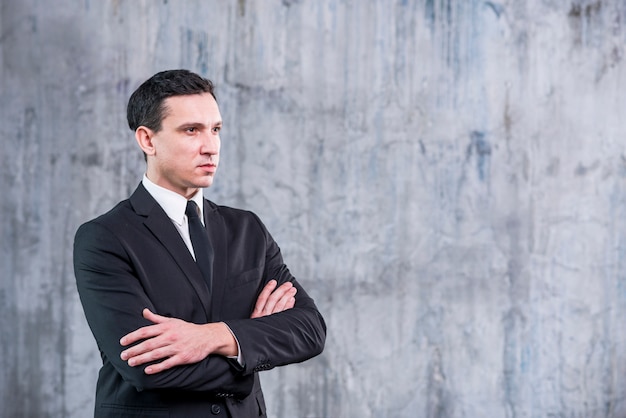 Businessman with arms crossed looking away