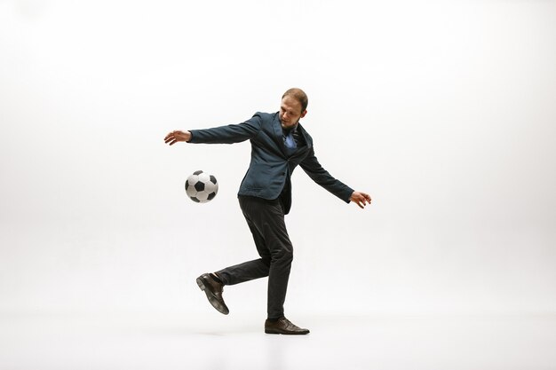 Businessman with football ball in office.