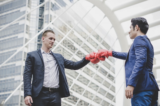 Free Photo businessman with red boxing gloves ready to fight his coworker.