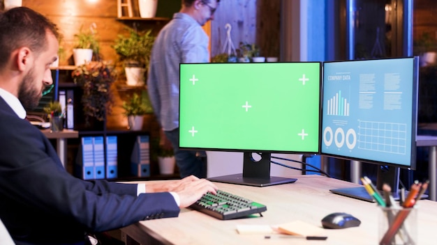 Free Photo businessman working on a computer with green monitor. office worker