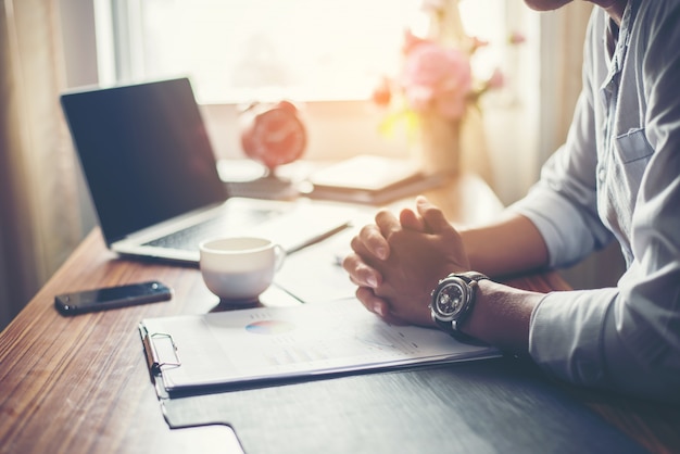 Businessman working on his desk with a cup of coffee at office.