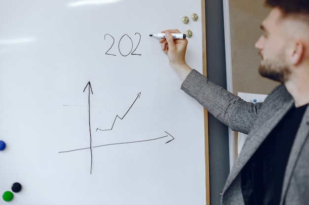 Free photo businessman working in the office.man holds a pen. guy writes on the poster