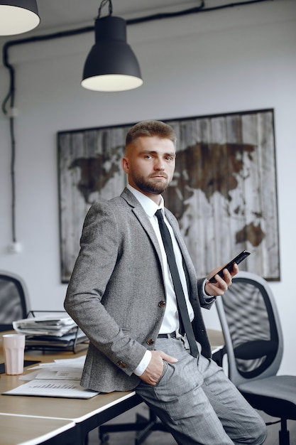 Free photo businessman working in the office.man uses the phone. guy is sitting in the office