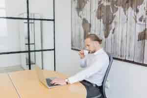 Free photo businessman working with laptop in office