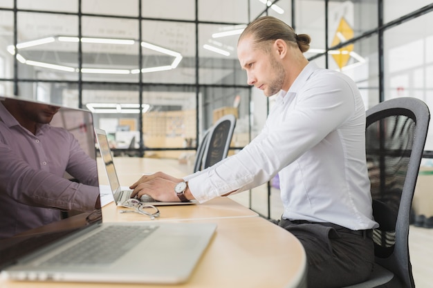 Free photo businessman working with laptop in office