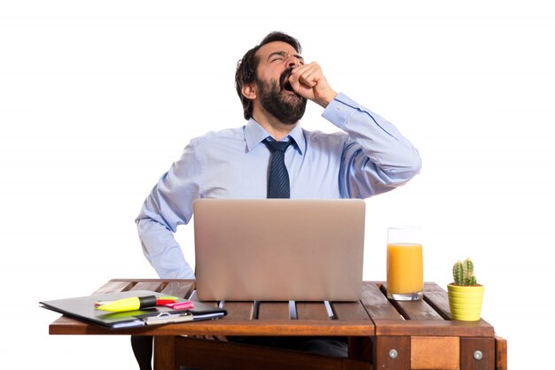 Businessman yawning in his office