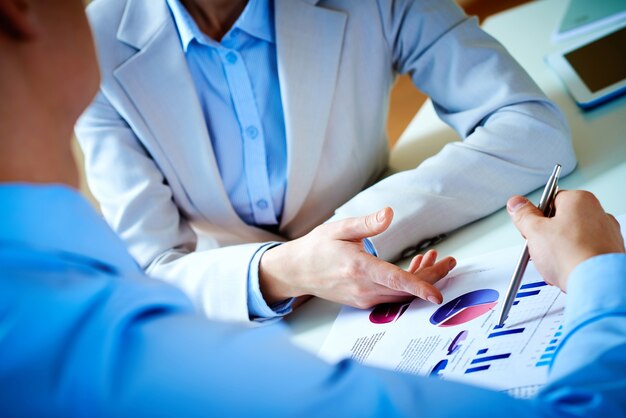 Businessmen analyzing bar charts at their workplace