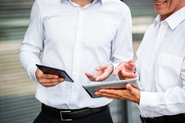 Businessmen looking at tablets