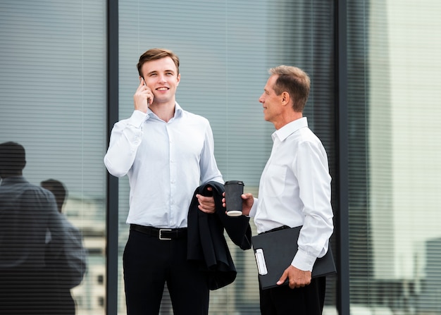 Businessmen outside of glass building