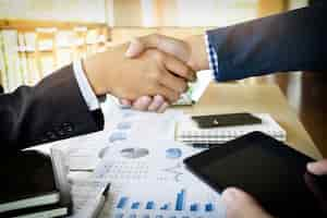 Free photo businessmen shaking hands during a meeting