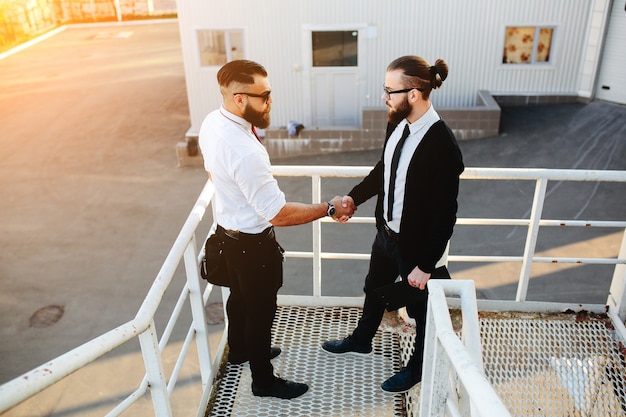 Free Photo businessmen shaking hands on stairs