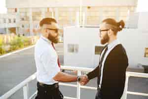 Free photo businessmen shaking hands on stairs