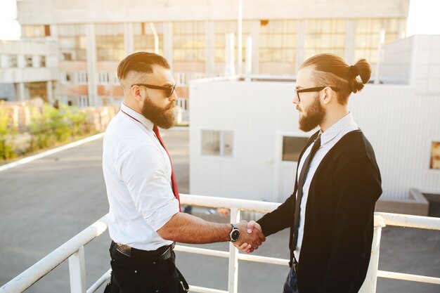 Free Photo businessmen shaking hands on stairs